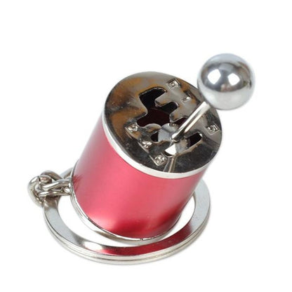 Red mini gear shift keychain with a metallic shifter lever and silver base on a white background