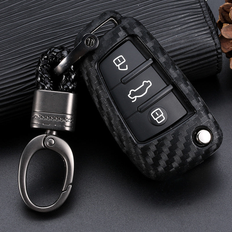 Premium carbon fiber car key fob for Audi with metallic keychain on dark background – shockproof protective key cover