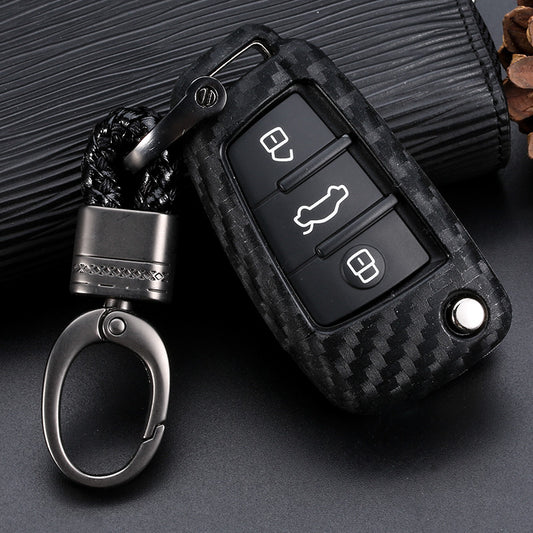 Premium carbon fiber car key fob for Audi with metallic keychain on dark background – shockproof protective key cover