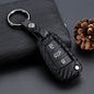 Black silicone car key fob cover with buttons displayed on a dark textured background
